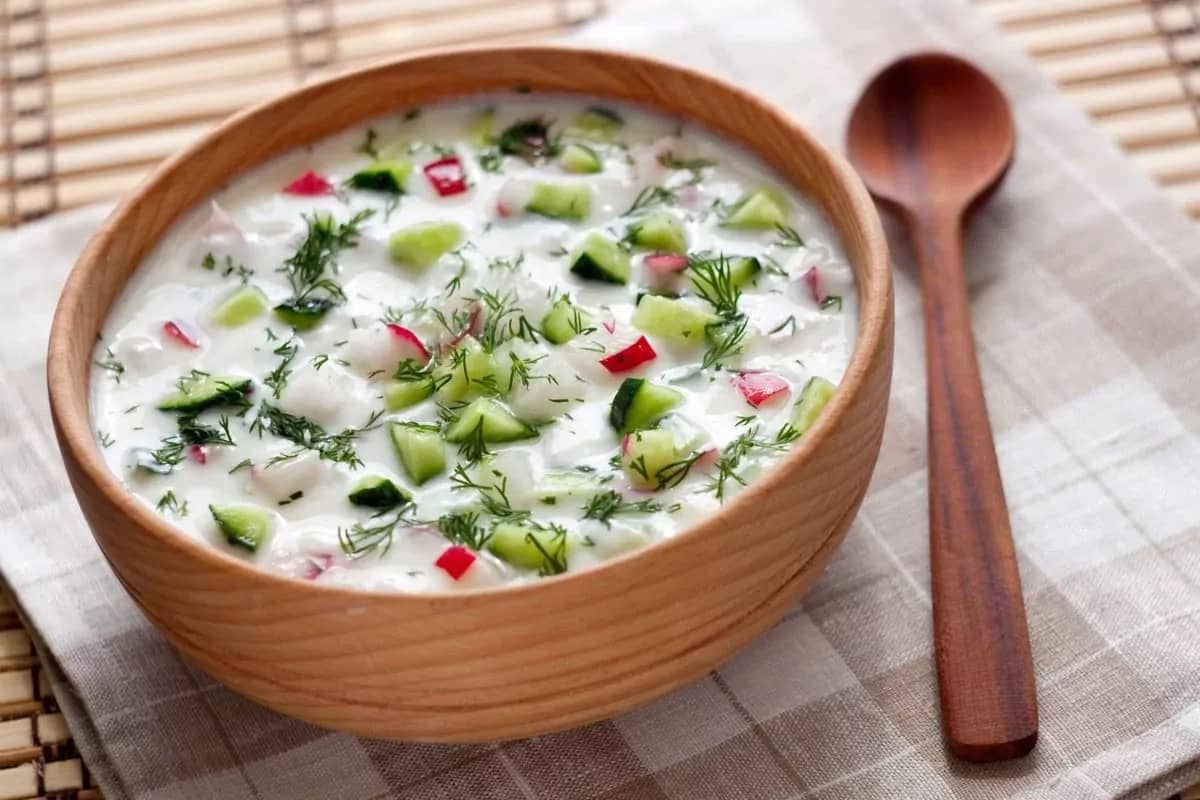 Bowl of traditional Okroshka soup with fresh vegetables.