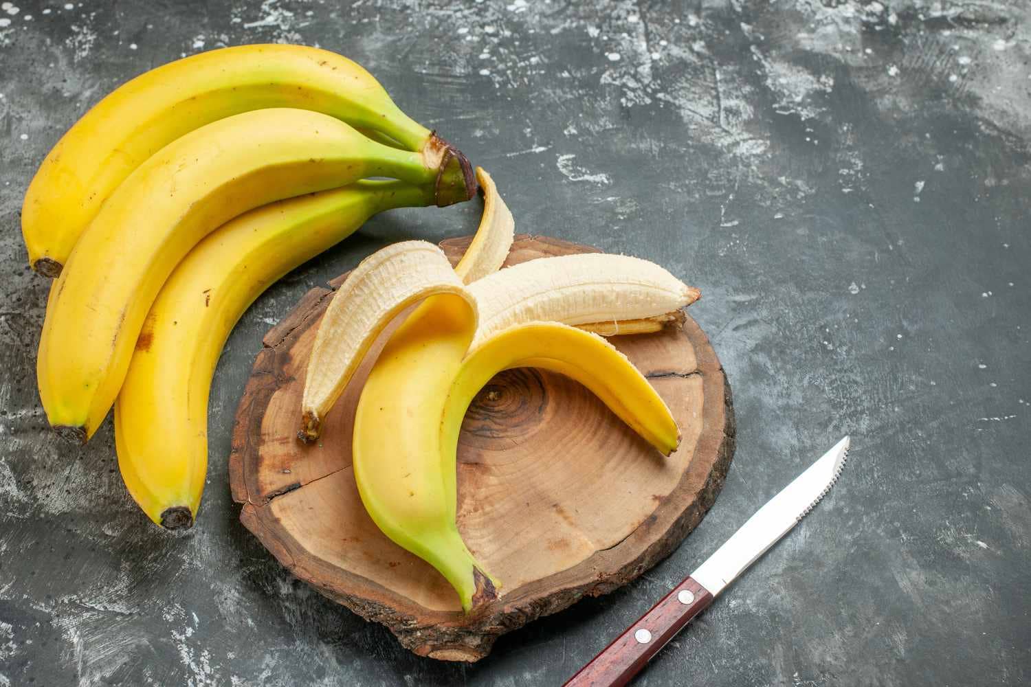 A glass of banana smoothie with a straw.