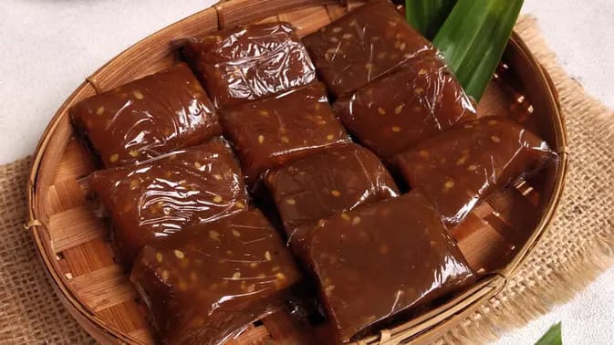 Gambar sebuah potongan dodol ketan yang menampilkan tekstur kenyal dan warna kecokelatan, menghadirkan kelezatan klasik yang telah dicintai oleh generasi-generasi