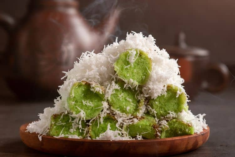 Kue Putu hijau segar, disajikan dengan taburan kelapa parut, menampilkan kelezatan tradisional yang khas