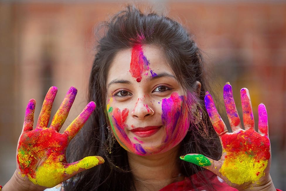 Participants joyfully throwing vibrant gulal during Holi 2024, symbolizing the victory of good over evil.