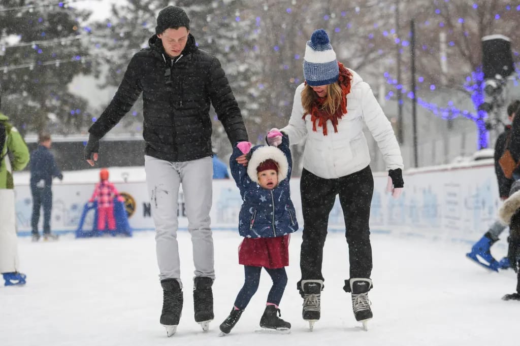 A group of friends enjoying a leisurely ice skating session on a frozen pond, surrounded by winter scenery.